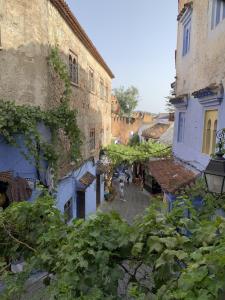 a group of people walking down a street in an alley at H&ocirc;tel Barcelona in Chefchaouene