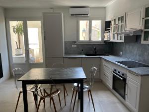 une cuisine avec une table et des chaises dans l'établissement Appartement de village avec balcon rooftop, à Maillane