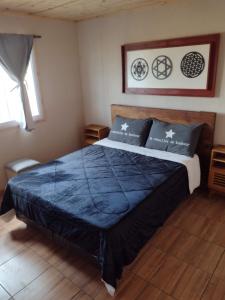 a bedroom with a bed with a blue comforter at Portal del Sol in Villa Yacanto