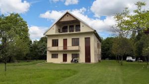 Patara EtseriHouse in the forest的带阳台的白色房子,位于草地上