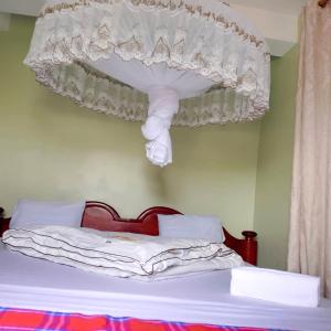 una camera con un letto a baldacchino bianco di Nyanyama Resort a Mwanza