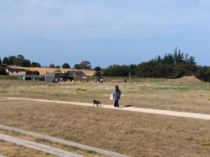 a woman walking a dog on a path at Maison en résidence in Langueux