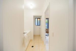 a white bathroom with a sink and a mirror at Springfield Breeze - Newly furnished home, Sunny Patio and BBQ in Goodna +33 photos