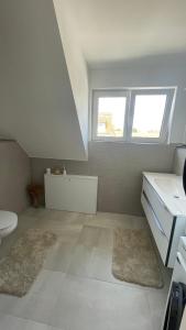 a white bathroom with a sink and a toilet at Ferienwohnung Licina in Lauenburg +7 photos