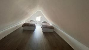 two beds in a attic with a window at Ferienwohnung Licina in Lauenburg