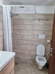 a bathroom with a toilet and a tile wall at Red Rose Tiburtina in Rome +18 photos