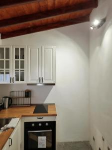 a kitchen with white cabinets and a black oven at La Colonial in Vega de San Mateo