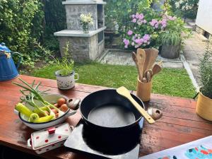 ein Topf und eine Schüssel mit Gemüse auf einem Tisch in der Unterkunft Green Garden Home in Cerknica