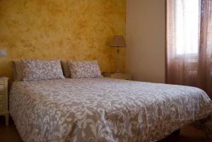 a bedroom with a bed with a white comforter and a window at La Casa Del Pueblo in Garganta de los Montes +11 photos
