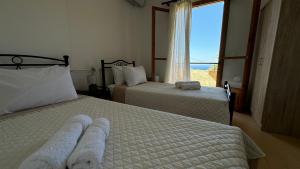 a hotel room with two beds and a window at Villa Kardi in Vlikhádha