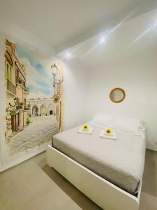 a bedroom with a bed with a painting on the wall at Bell'Arè in Barletta
