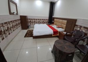 a bedroom with a bed and a table and chairs at Abrol residency in Katra