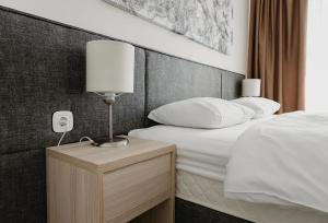 Un dormitorio con una cama y una lámpara en una mesita de noche. en Yes Botanical Apartments, en Astana 12 fotos más