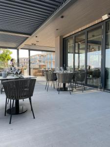 un patio esterno con tavoli, sedie e finestre di Lägenhet på stranden i Åhus med havsutsikt och bastu samt relax ad Åhus