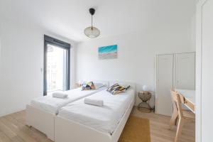 a white bedroom with a bed and a desk at L'Ambre - T2 Lumineux - Parking, RER A, Disneyland in Montévrain