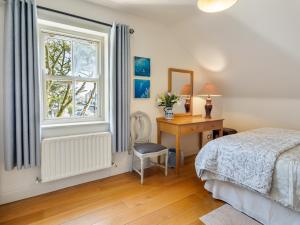 a bedroom with a bed and a desk and a window at Ard Apartment, Roundstone in Roundstone
