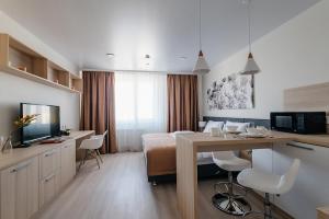 Una habitación de hotel con una cama, una mesa y una cocina. en Yes Botanical Apartments, en Astana