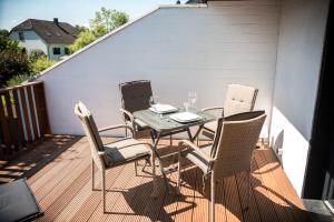 a table and four chairs on a deck at Terrassenwohnung mit Gartenblick in Solingen