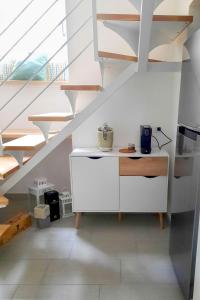 a kitchen with a white cabinet and stairs at Il Nido di Nenna Apartment in Meta