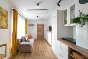 a living room with white cabinets and a couch at Apartament w Sercu Gór z ogrodem in Wałbrzych