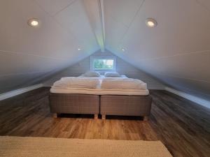a bedroom with a bed in a attic at Fridfullt läge, stuga med sjöutsikt in Säffle