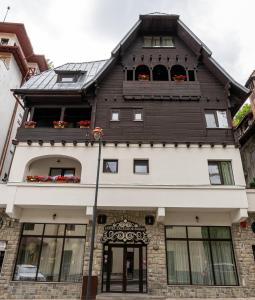 un edificio con flores en las ventanas en Excelsior Boutique Hotel Sinaia, en Sinaia
