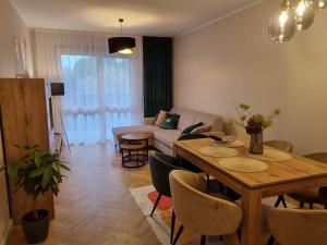 a living room with a table and a couch at Apartament 55 z miejscem w garażu in Toruń