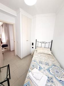 una camera da letto bianca con un letto e una sedia di Apartamento Lola2 a Nerja