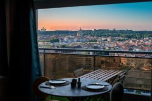 einen Tisch mit Stadtblick aus dem Fenster in der Unterkunft Studio avec vue panoramique et parking gratuit in Brüssel
