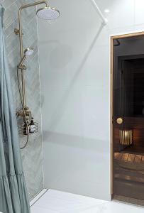 a shower in a bathroom with a blue shower curtain at Mere Apartment - Private Yard, Sauna and Pet Friendly in Pärnu +26 photos