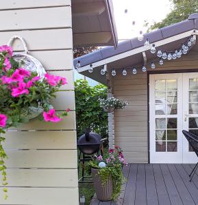 a patio with pink flowers and a door at Mere Apartment - Private Yard, Sauna and Pet Friendly in Pärnu