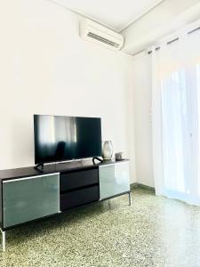 a living room with a flat screen tv on a entertainment center at GRACE Apartment Next to the Akropolis in Athens +40 photos