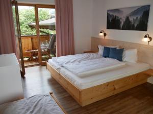 a bedroom with a large bed with blue pillows at Haus Thussn, Ferienwohnung für Familien und Paare in Kirchberg in Tirol +26 photos