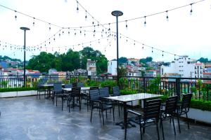 eine Gruppe von Tischen und Stühlen auf einer Terrasse mit Lichtern in der Unterkunft Indigen Riverside Hotel Cao Bang in Cao Bằng