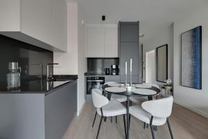a kitchen with a table and chairs in a room at Scala 3 by Grand Apartments in Gdańsk