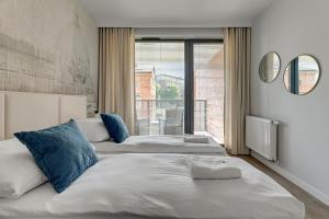 two beds in a room with a large window at Scala 3 by Grand Apartments in Gdańsk