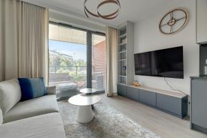 a living room with a couch and a tv at Scala 3 by Grand Apartments in Gdańsk