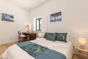 a bedroom with a bed and a desk in it at Casa das Camarinhas in Aveiro