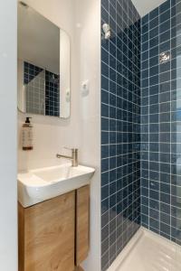 a bathroom with a sink and a shower with blue tiles at Casa das Camarinhas in Aveiro +24 photos