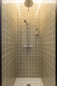 a shower in a tiled bathroom with a tub at Casa das Camarinhas in Aveiro