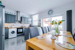 a kitchen with a table with a vase of flowers on it at Trent House - Quality 3 Bedroom House Lytham in Brown Moss Side
