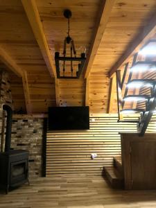 Cette chambre dispose d'un plafond en bois et d'un poêle. dans l'établissement Durmitor Home Mia, à Žabljak