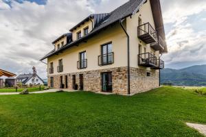 an exterior view of a house with a green lawn at Apartmán Simon - Horský Resort Buková Hora - Červená Voda in Červená Voda