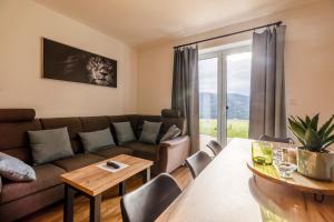 a living room with a couch and a table at Apartmán Simon - Horský Resort Buková Hora - Červená Voda in Červená Voda