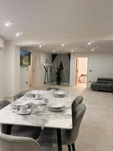 a white dining room with a table and chairs at Mote Park View in Kent