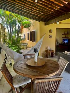 Una mesa y sillas de madera en una sala de estar. en Casa Praia dos Carneiros, en Praia dos Carneiros
