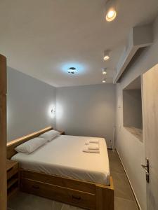 a bedroom with a bed with white sheets at Manis apartment in Prinos +5 photos