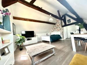 a living room with a wooden table and a couch at L Écuyer appartement au cœur du quartier historique in Chartres
