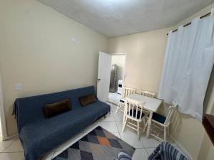 a living room with a blue couch and a table at Apto no centro de nova friburgo 1 in Nova Friburgo
