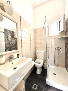 a white bathroom with a sink and a toilet at Aegeo Inn in Antiparos